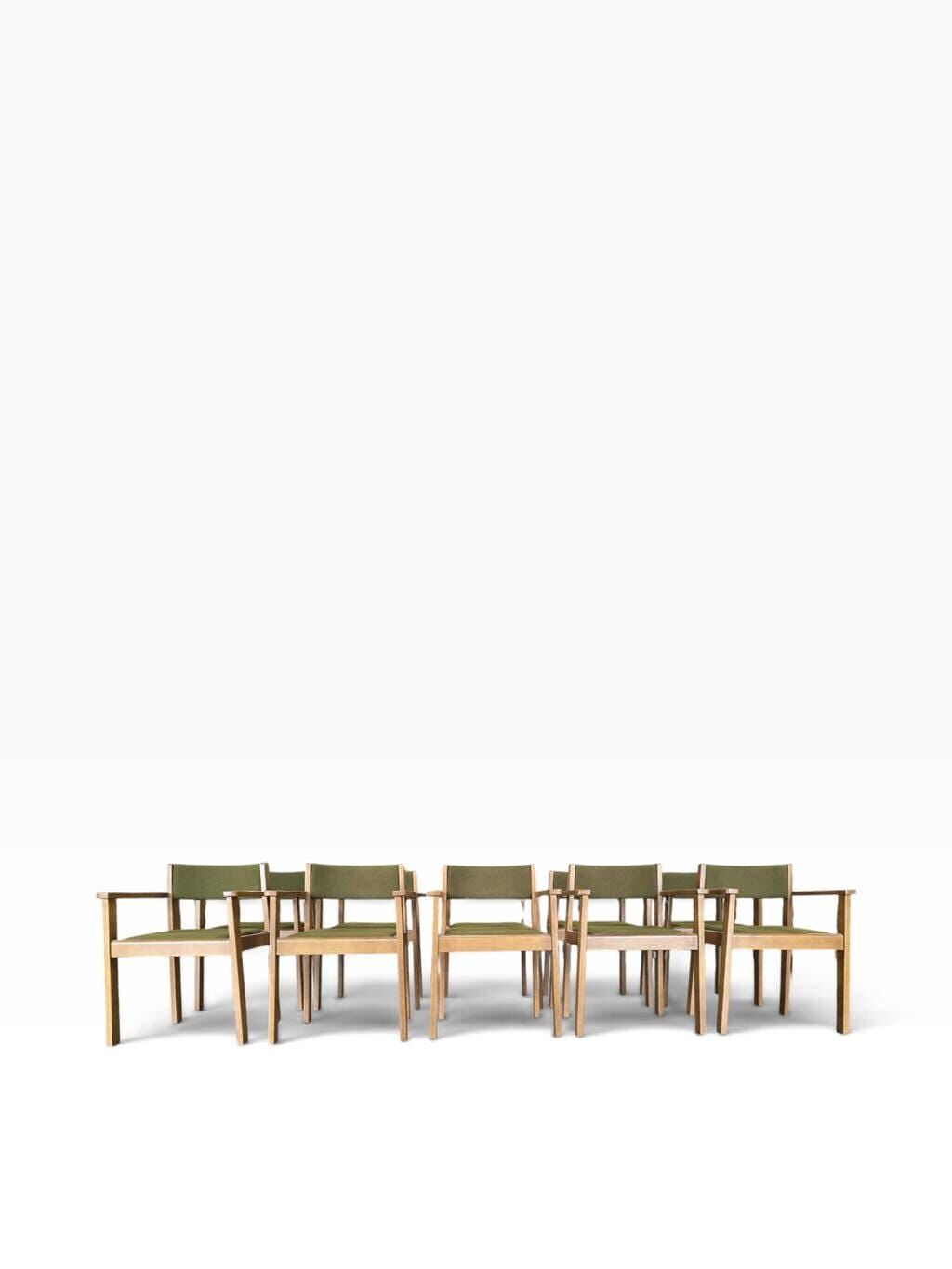 Vintage wooden chair with olive green seat and armrests.