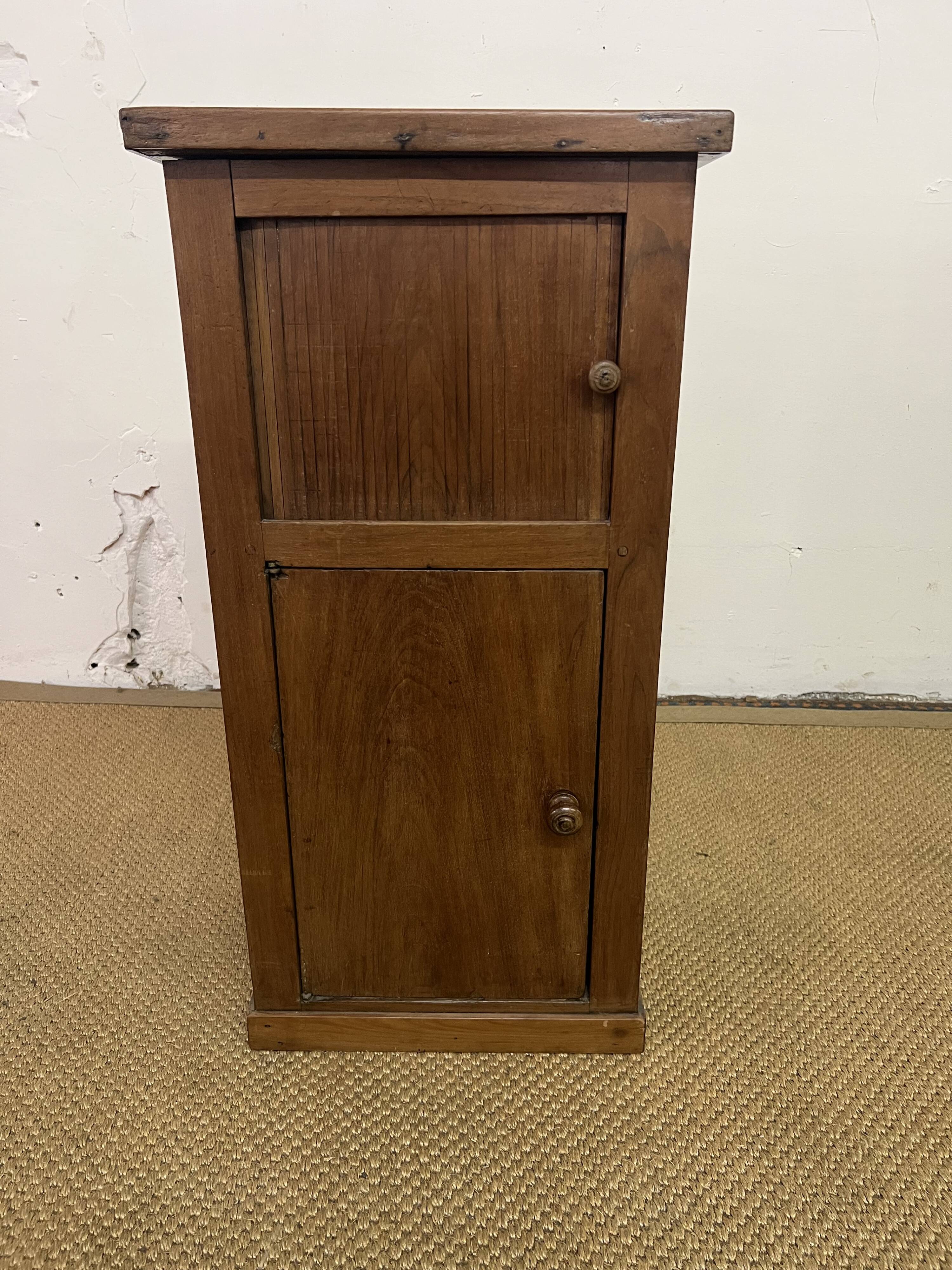 Old small storage unit with sliding and hinged doors.
