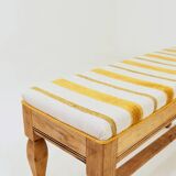 Vintage oak bench with striped linen fabric in a country style.