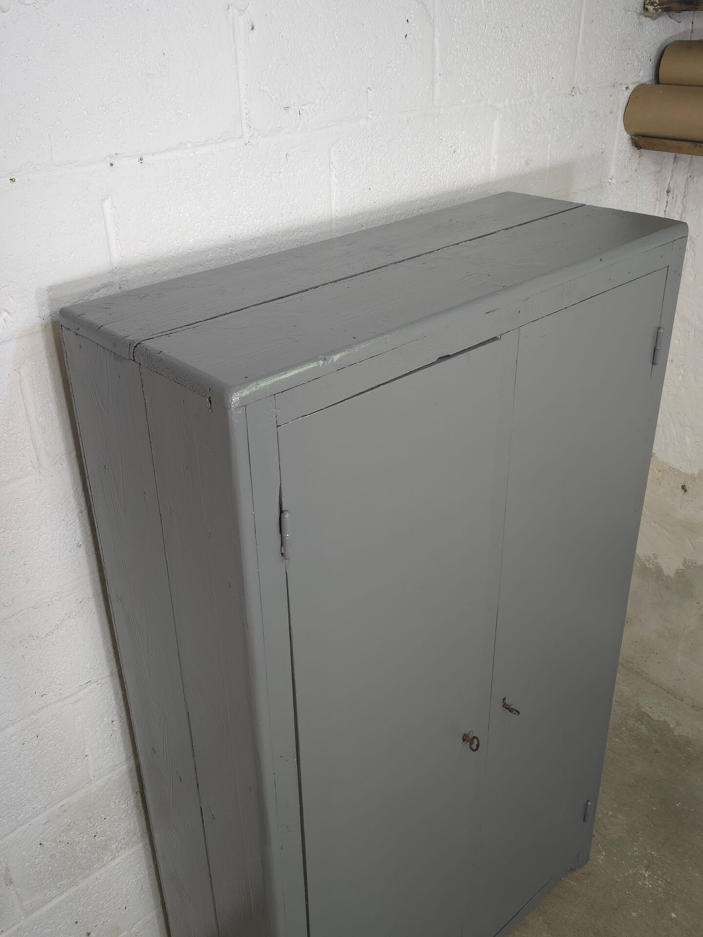 Curved wardrobe workshop locker made of wood repainted in grey.