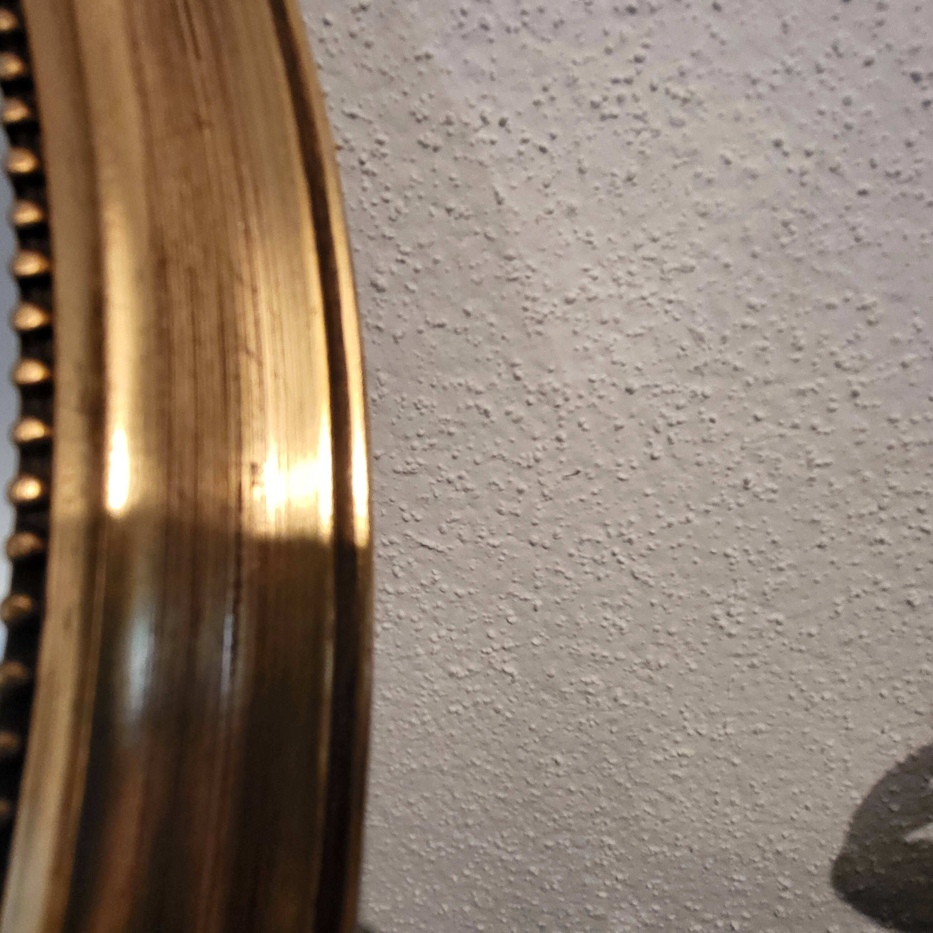 Oval mirror with golden wooden knot