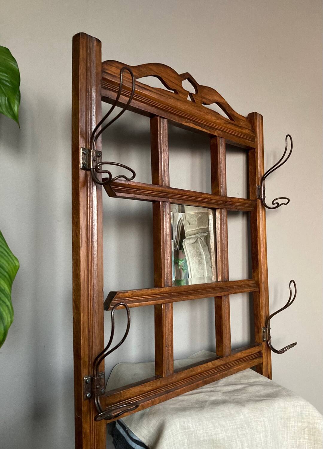 Art Deco wall-mounted coat rack in oak, early 20th century. Beveled central mirror
