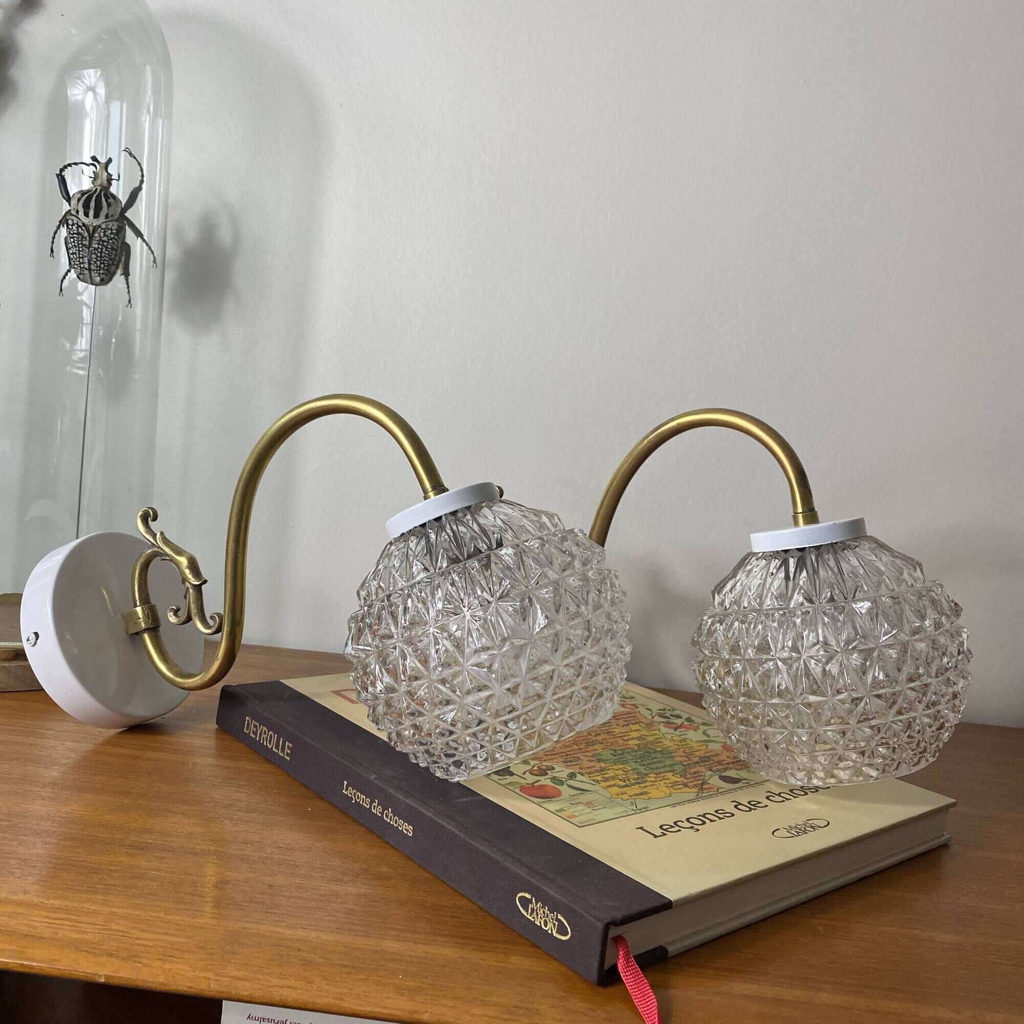 Large pair of brass swan neck wall lights with transparent glass globes.