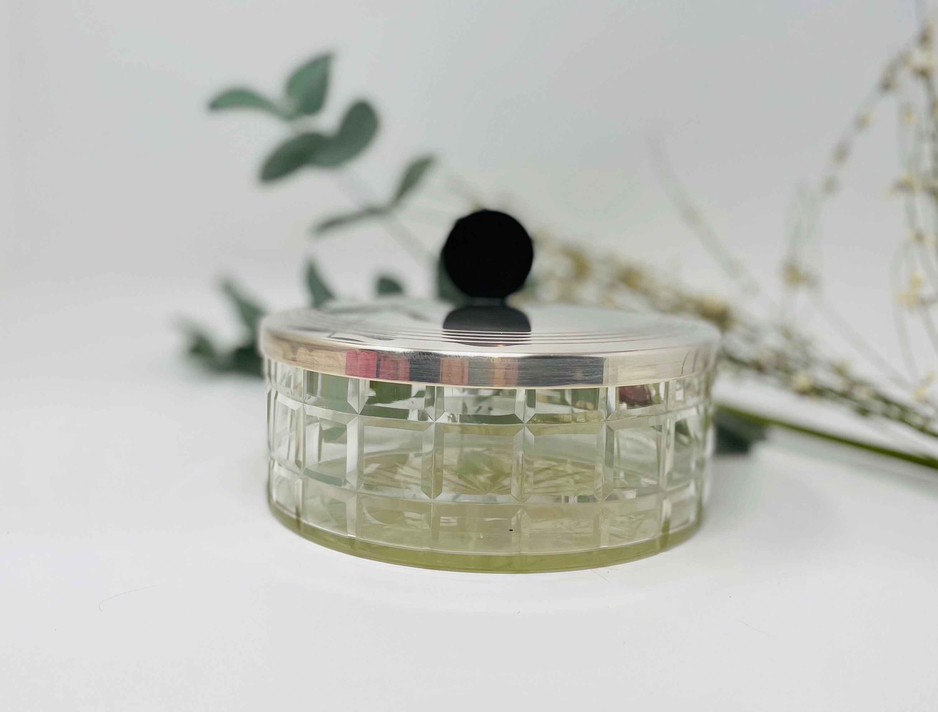 Vintage box made of chiseled glass and covered metal, taken in black Bakelite