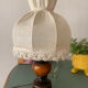 Small vintage wooden turned table lamp with a pleated shade.