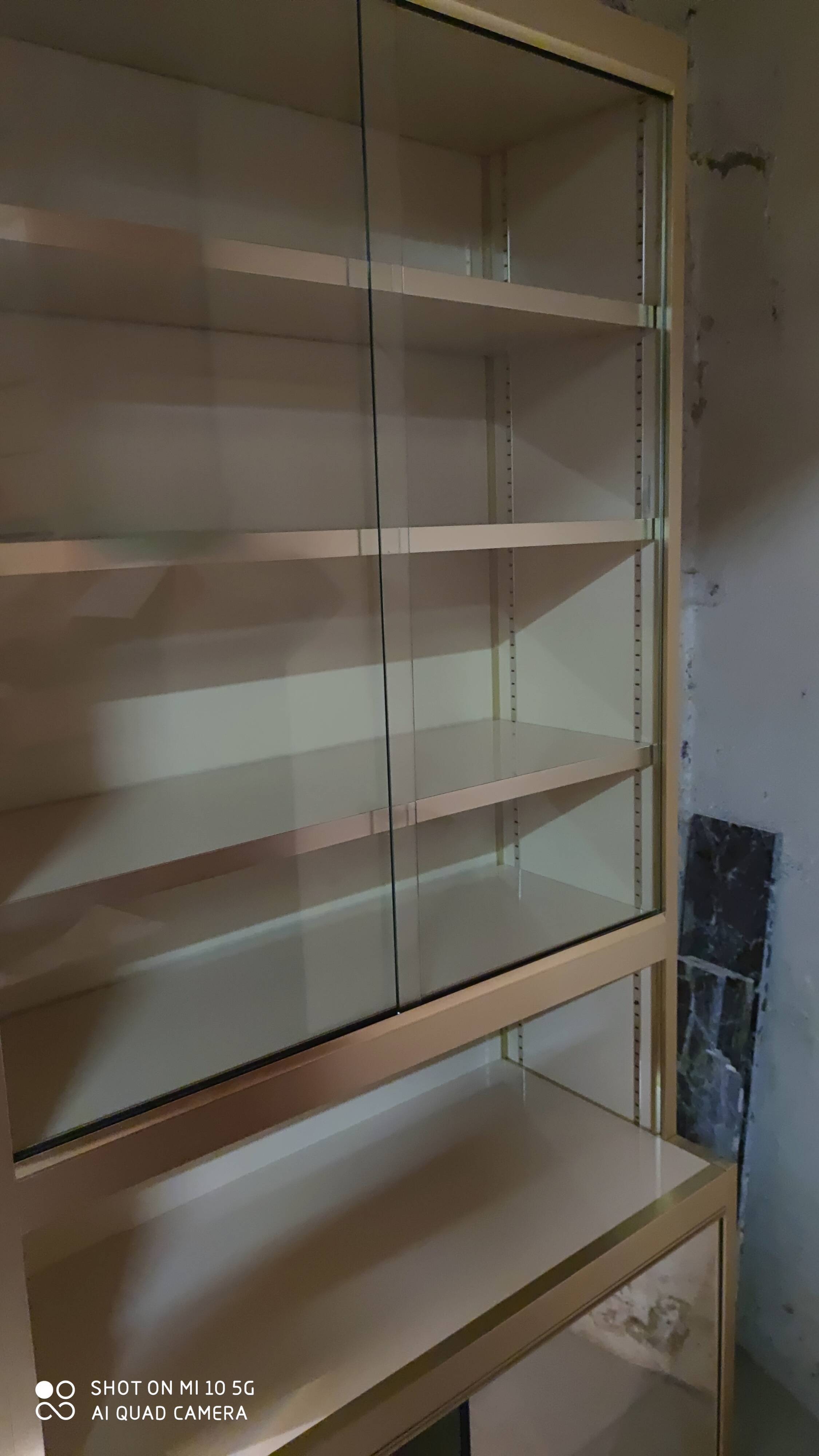 Ivory-colored and matte gold anodized aluminum display bookcase