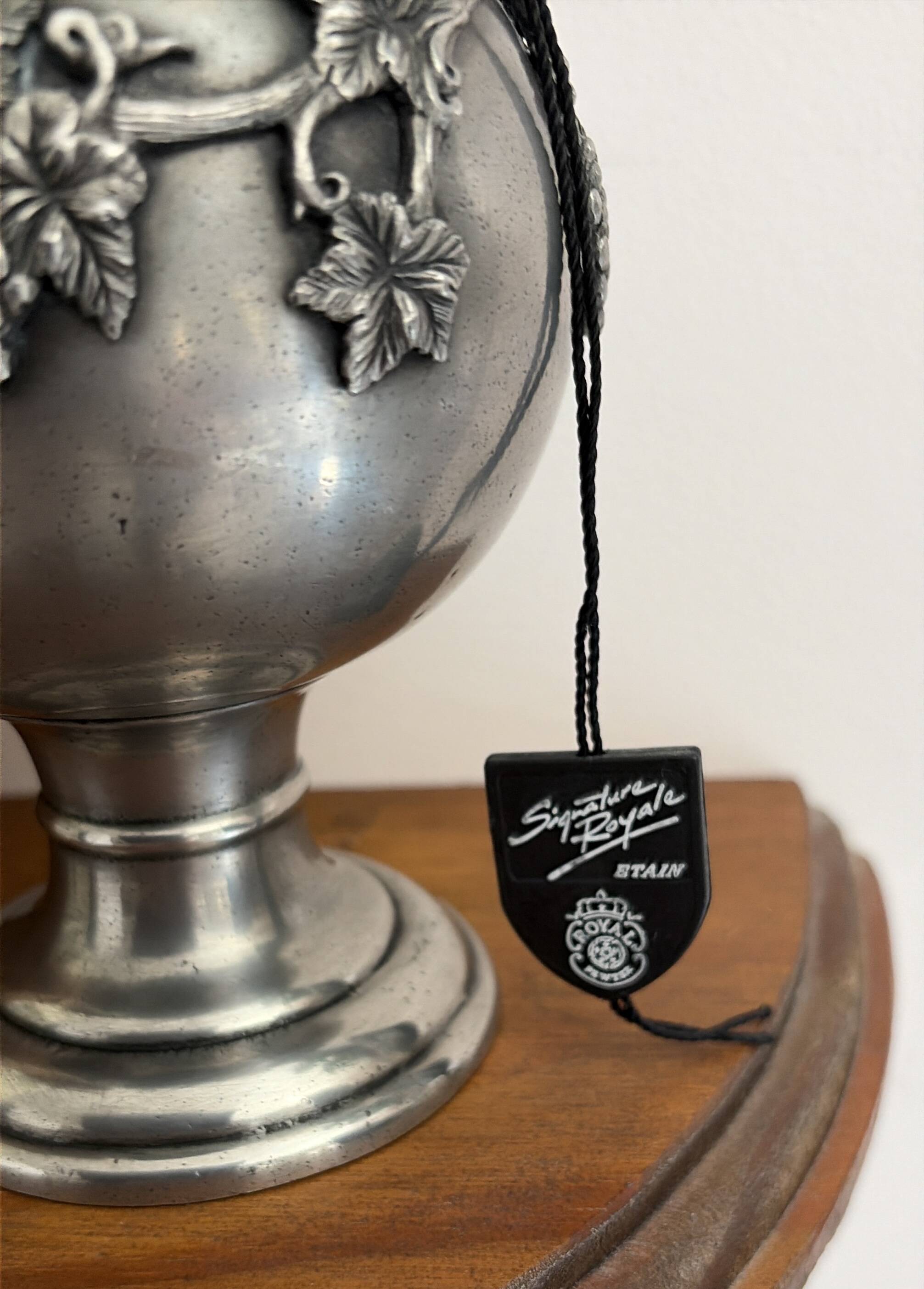 Ewer in pewter surrounded by vine branches with g