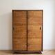 Vintage 1950s wardrobe with sliding wooden doors.