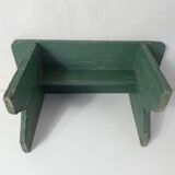Old small wooden bench with green foot