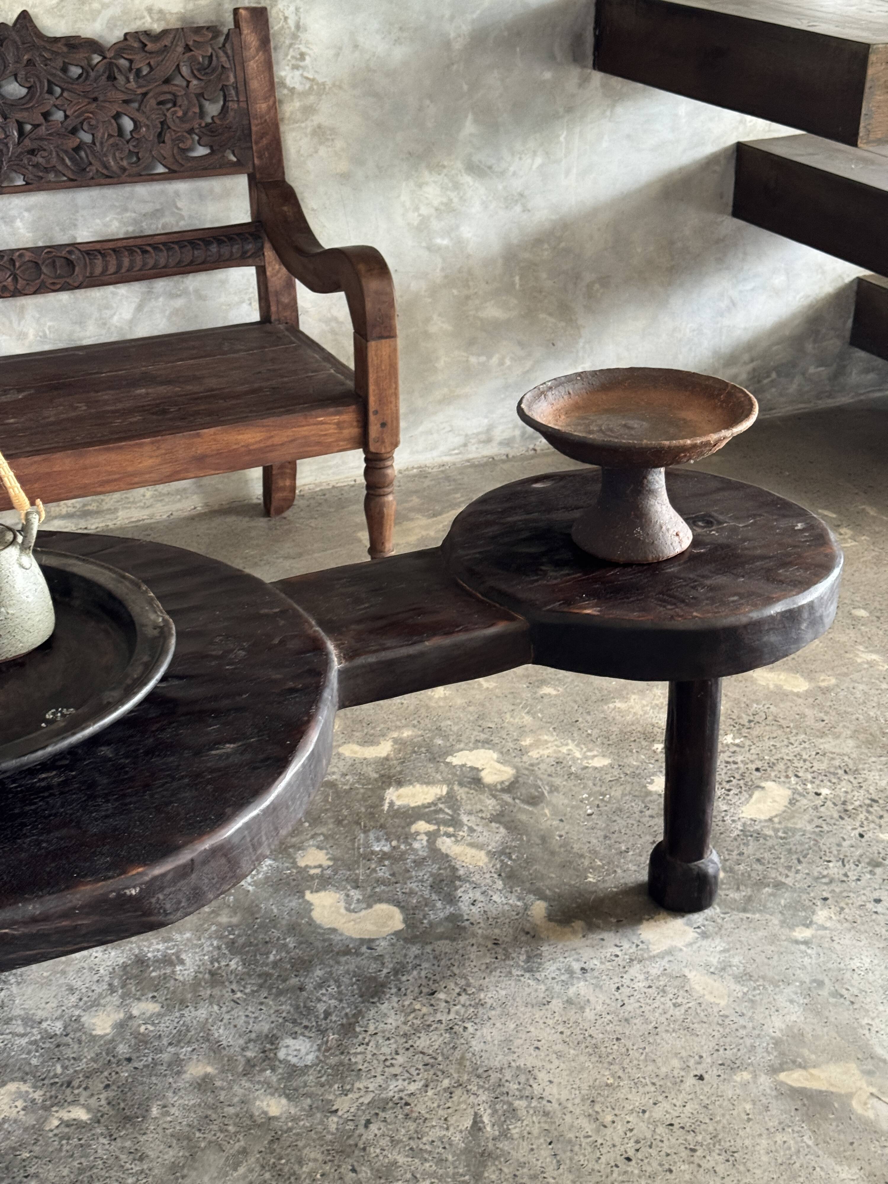 Small antique Indonesian bench in carved teak with plant and floral motifs.