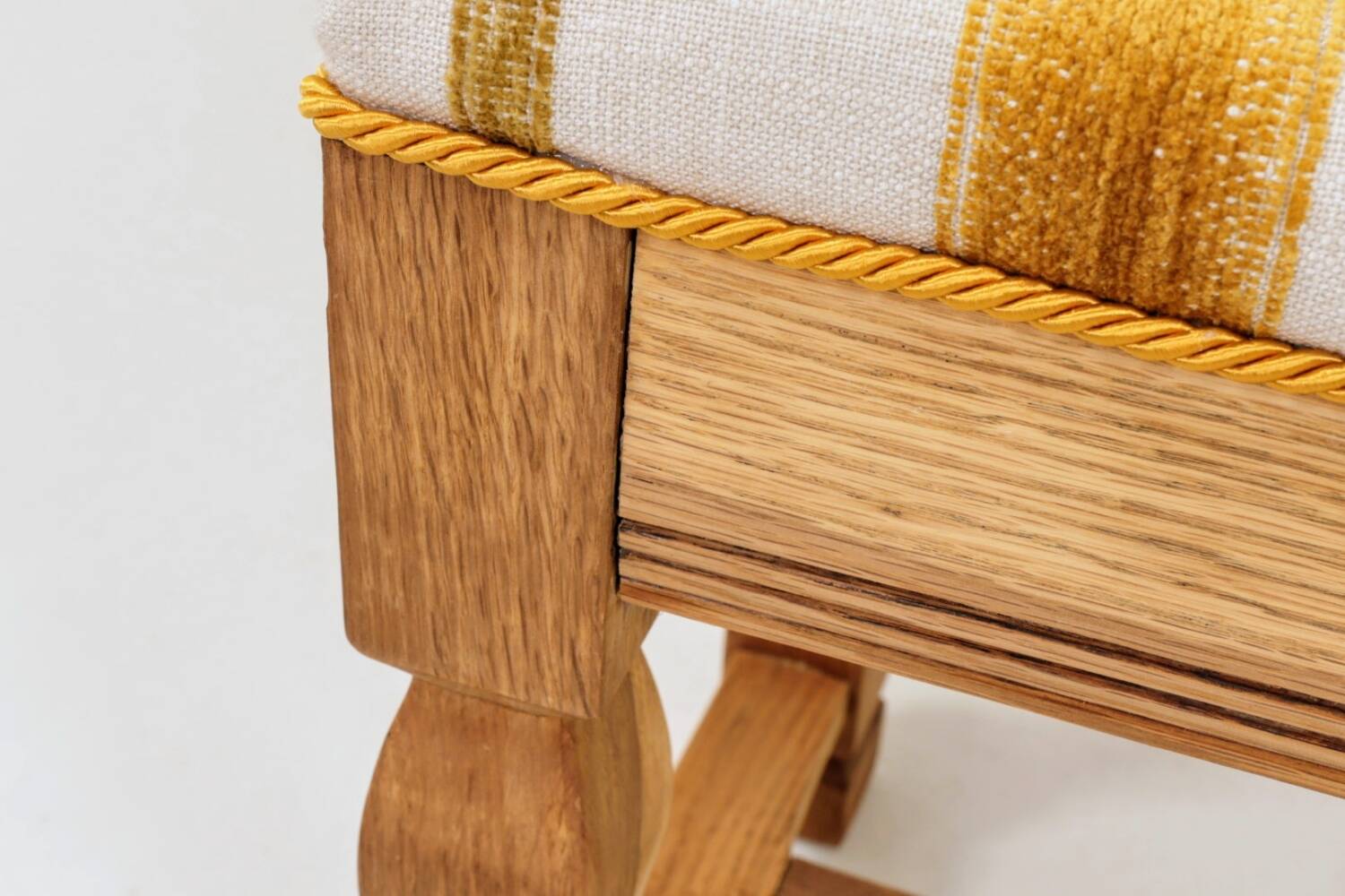 Vintage oak bench with striped linen fabric in a country style.