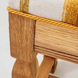Vintage oak bench with striped linen fabric in a country style.