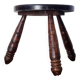 Small brutalist tripod stool made of turned wood.
