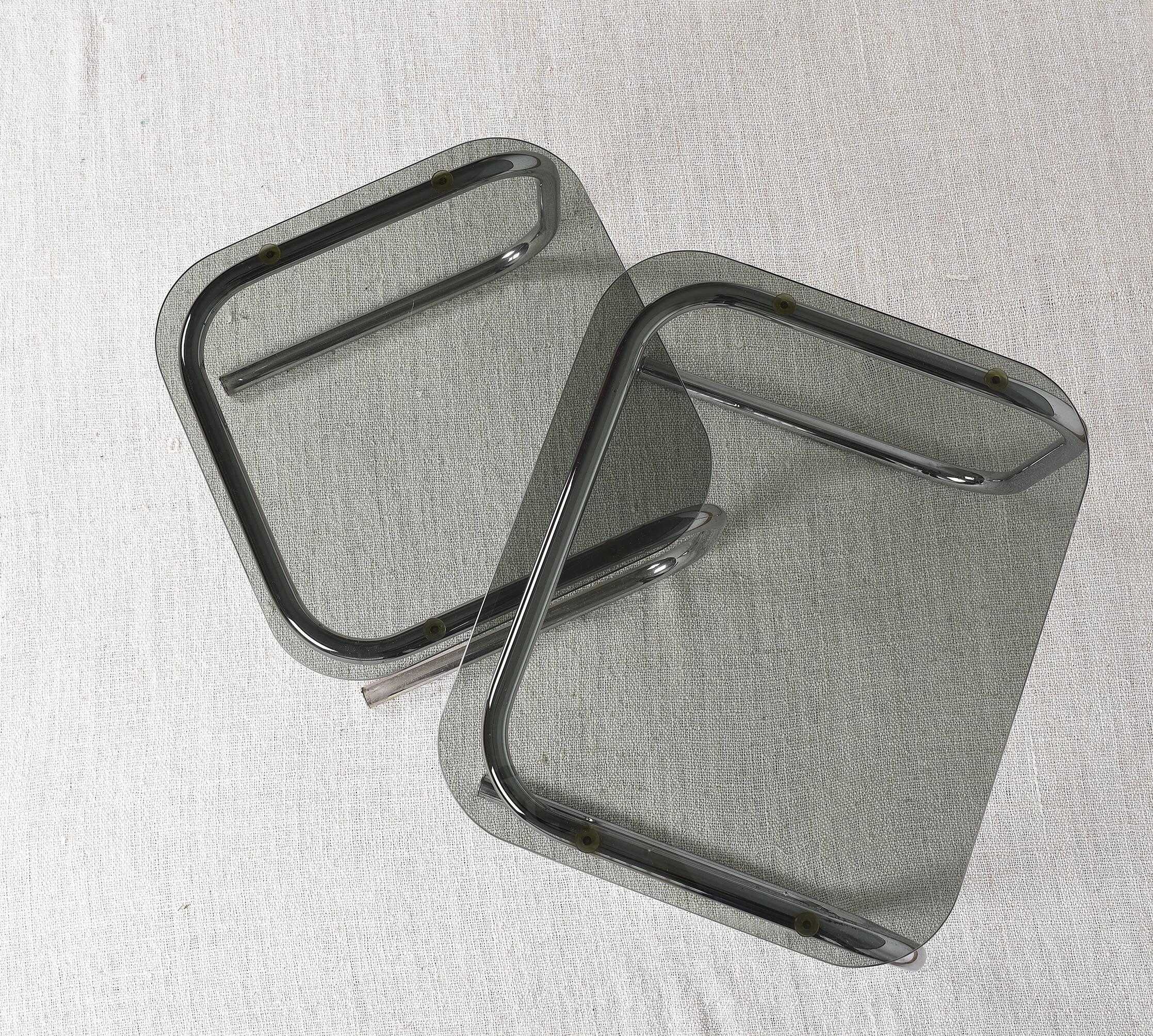Pair of nesting tables in smoked glass and chrome legs.