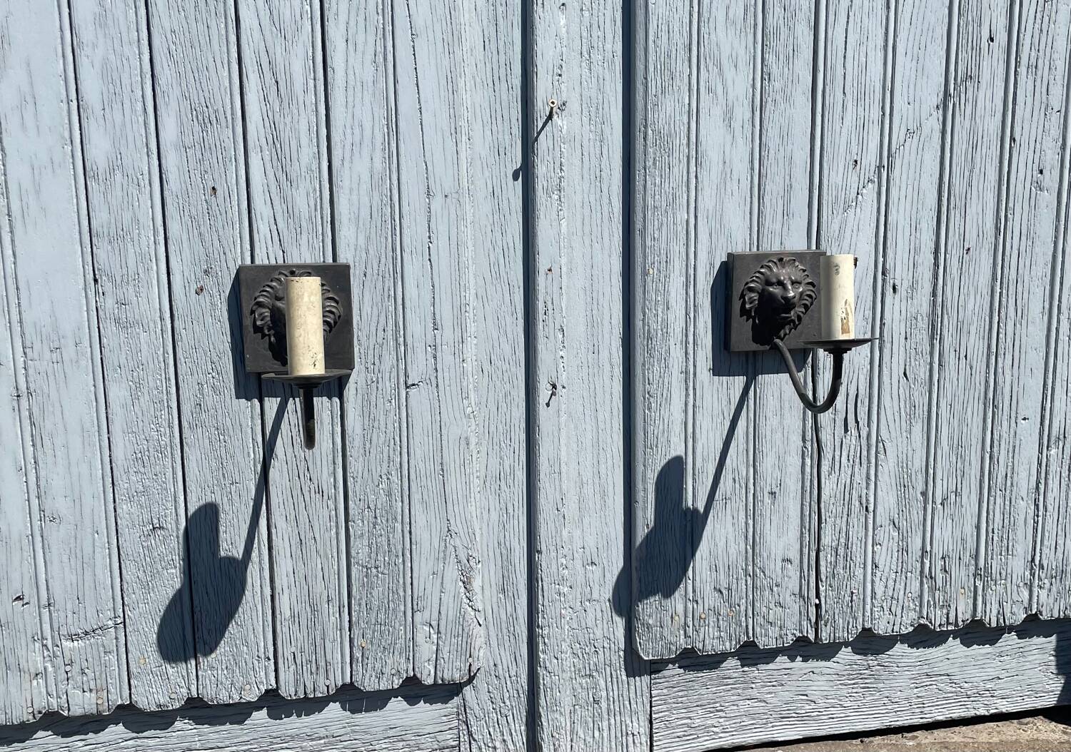 Two lion head wall sconces in tin.
