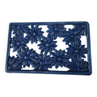 Blue cast iron trivet with flowers, small chip in the paint otherwise very good.