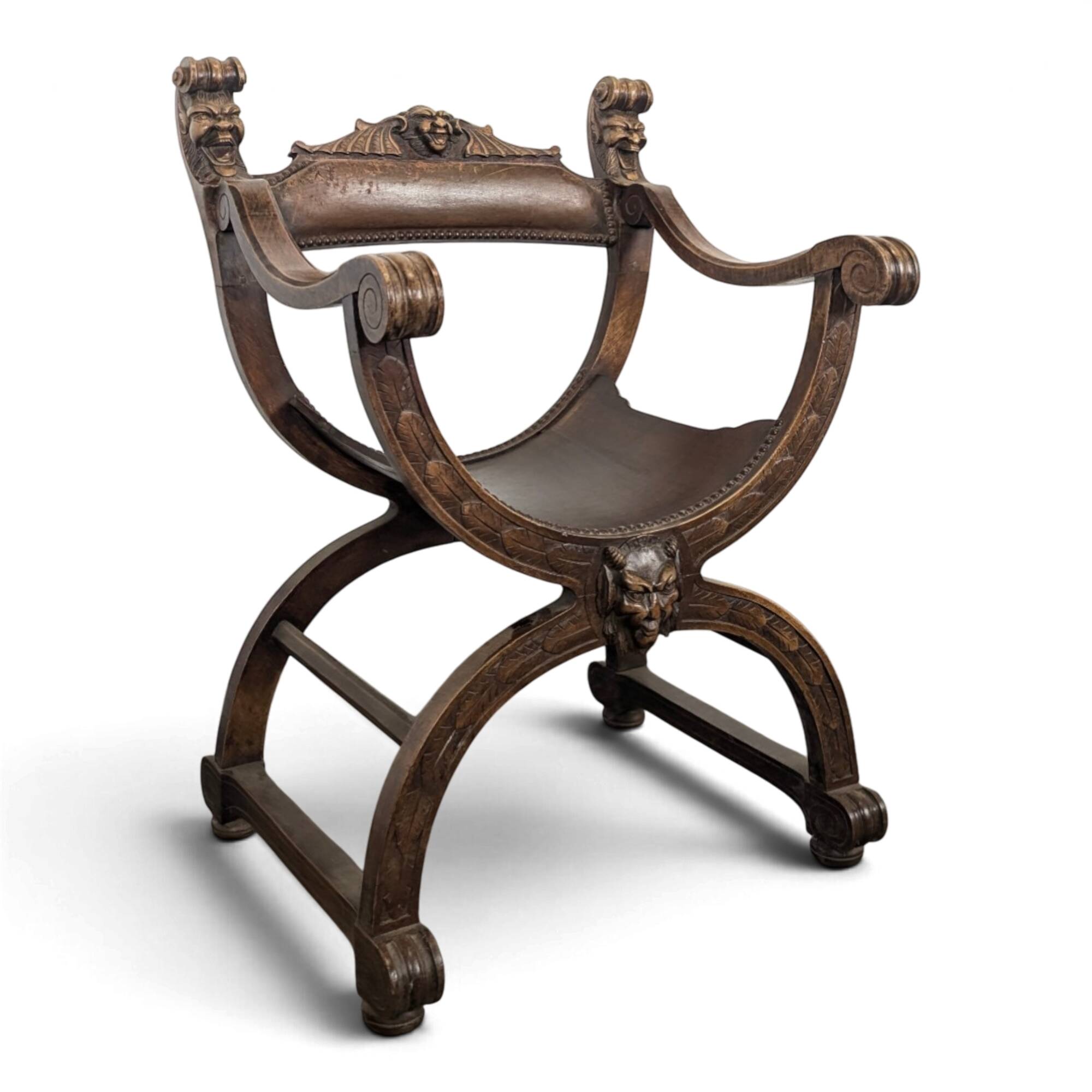 Curule chair Dagobert in carved walnut with lion heads.