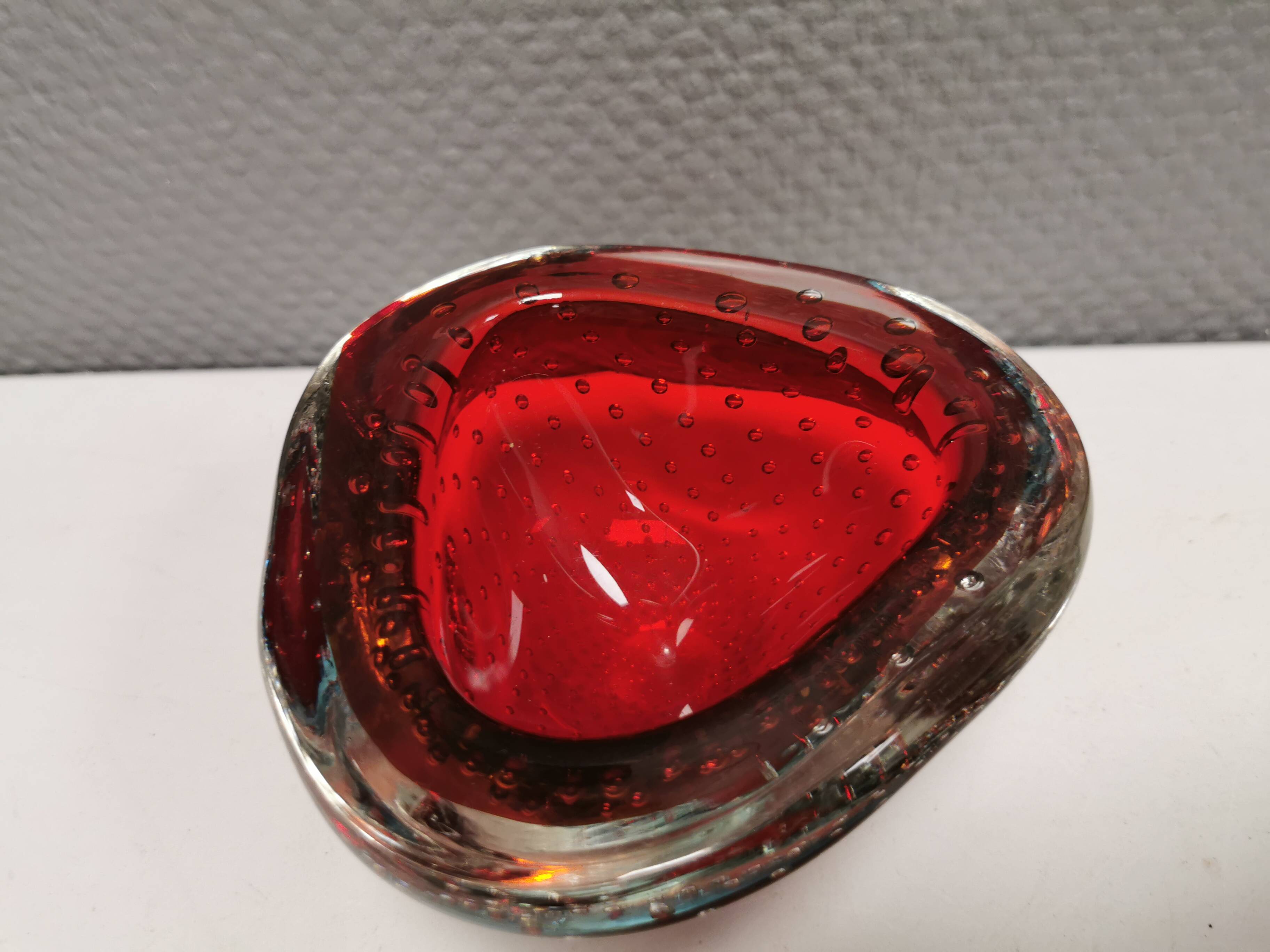 Small glass bowl in beautiful emerald red color with inlaid bubbles.