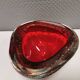 Small glass bowl in beautiful emerald red color with inlaid bubbles.