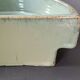 Glazed stoneware jardinière in almond green, semi-circular, signed.