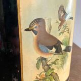 Metal wastebasket with bird decoration