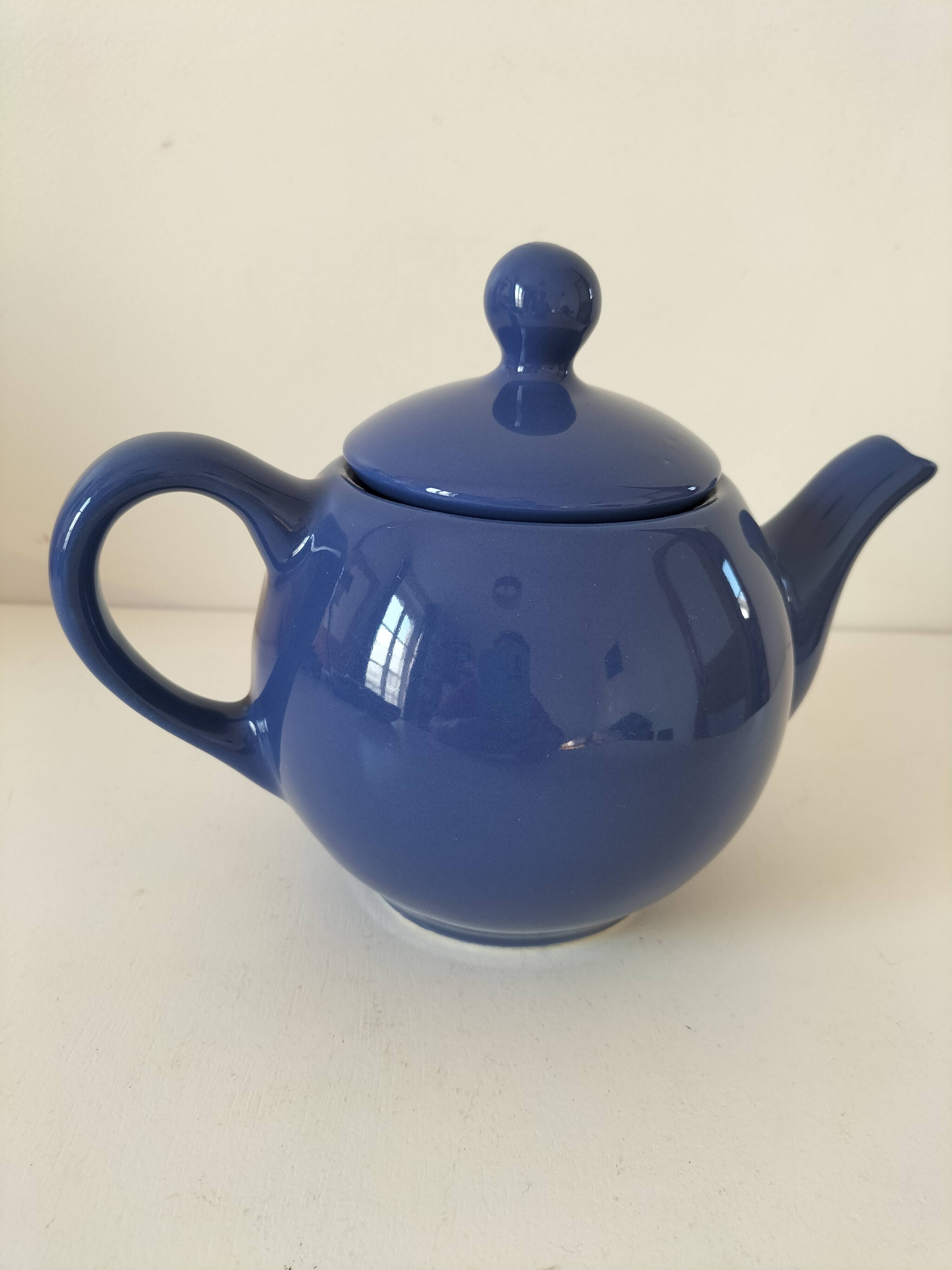 Vintage deep blue teapot, minimalist round shape.