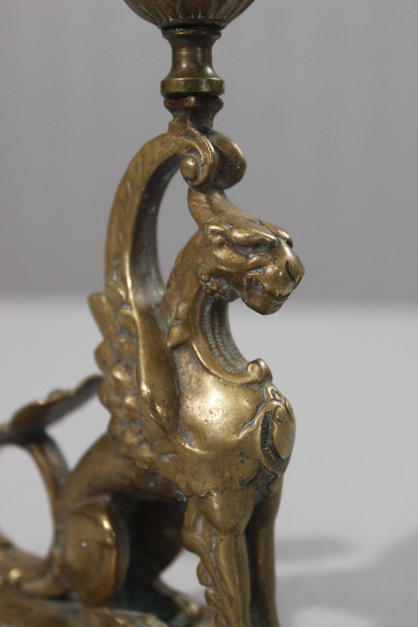 Handheld candlestick in bronze featuring a griffin, 19th-century Empire style.