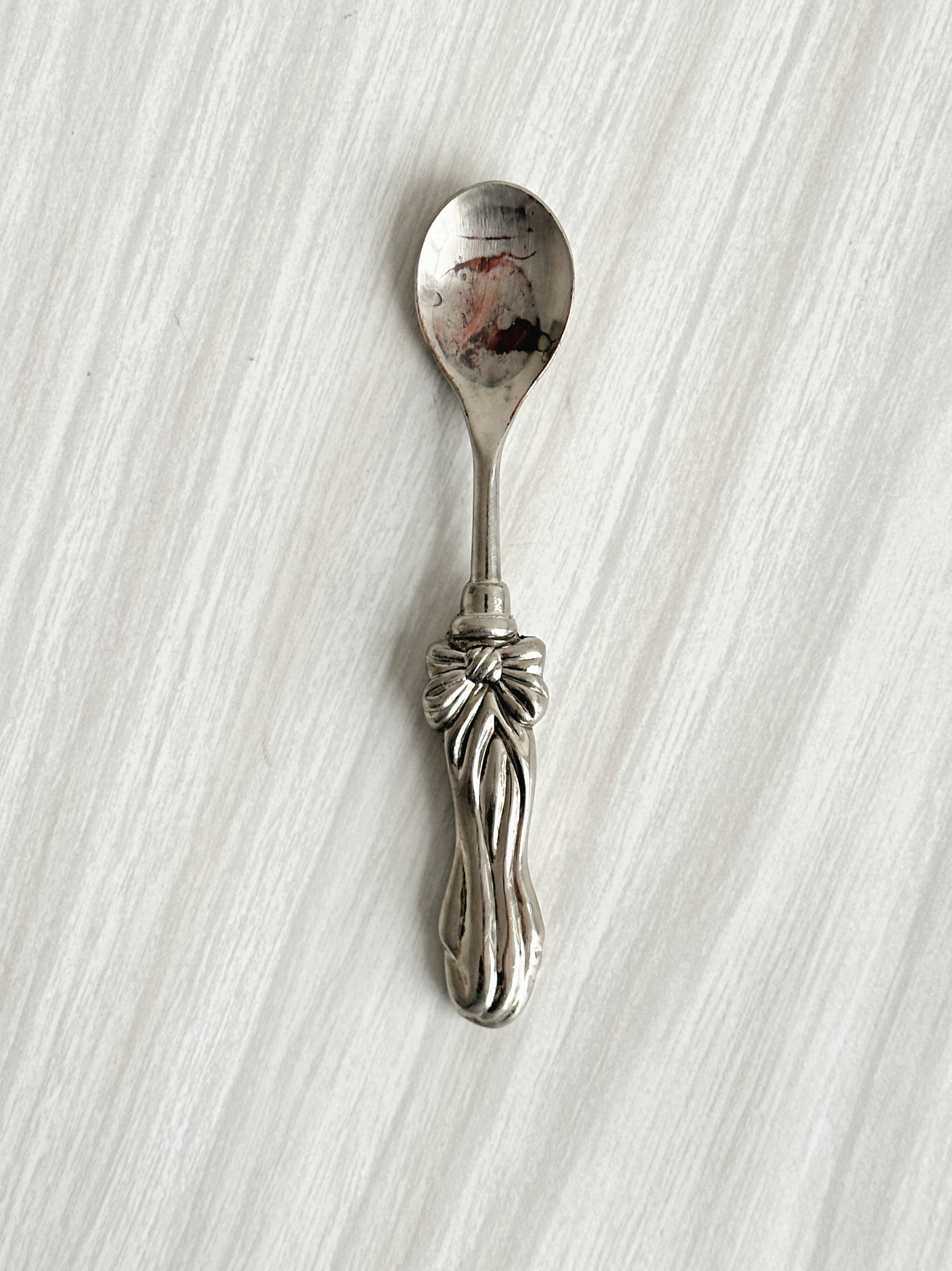 Antique small spoons with a metal bow design