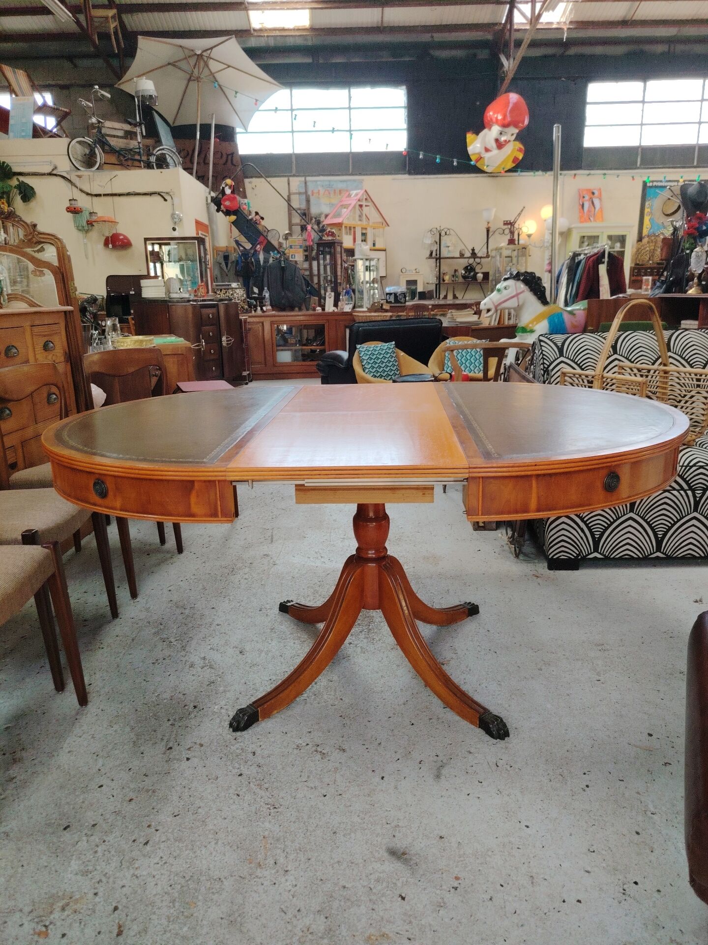 Round Regency dining table in mahogany and green leather with extensions - 20th century