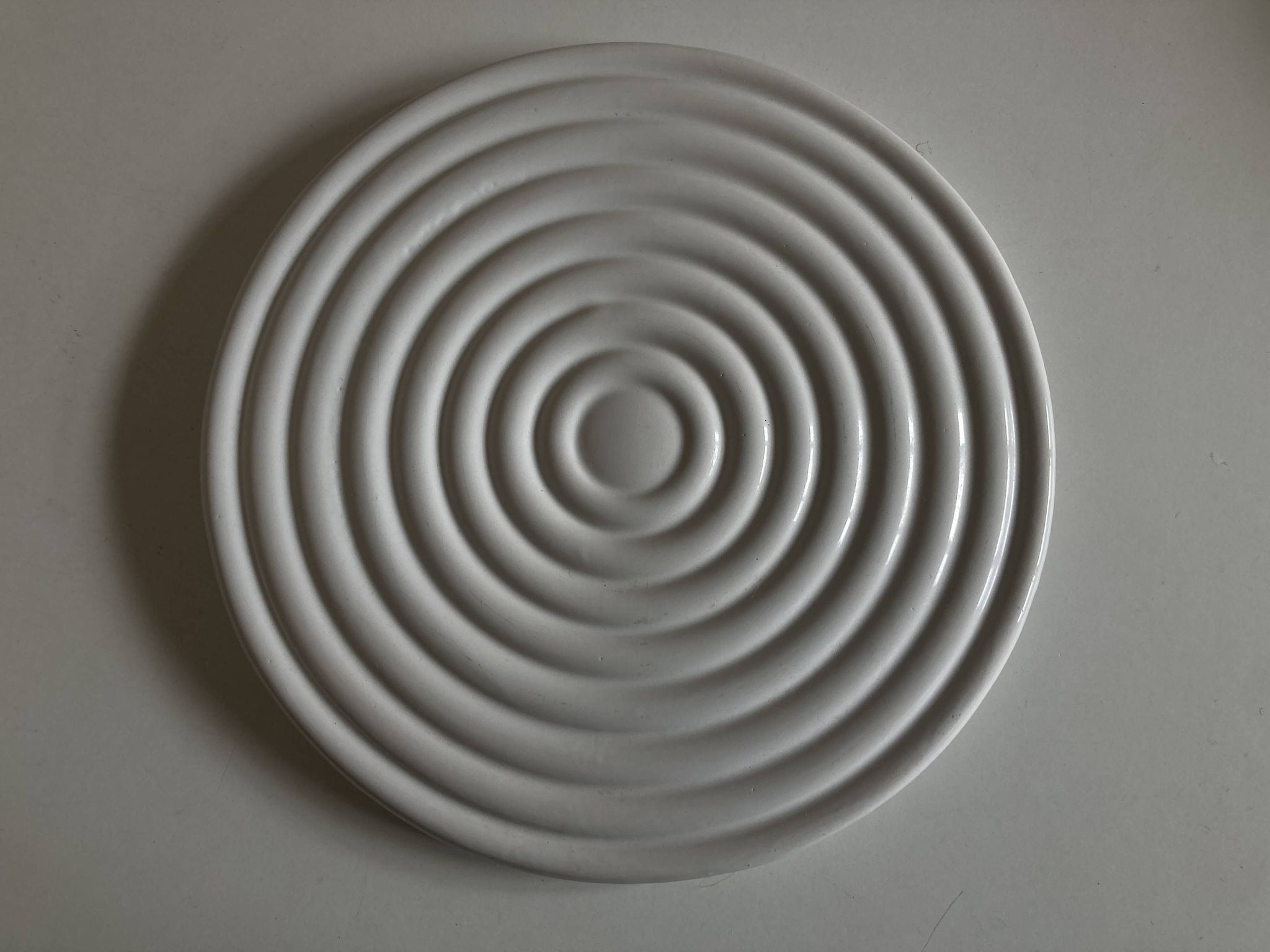 White glazed earthenware potter's trivet