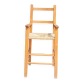 Old wooden high chair for children with straw.