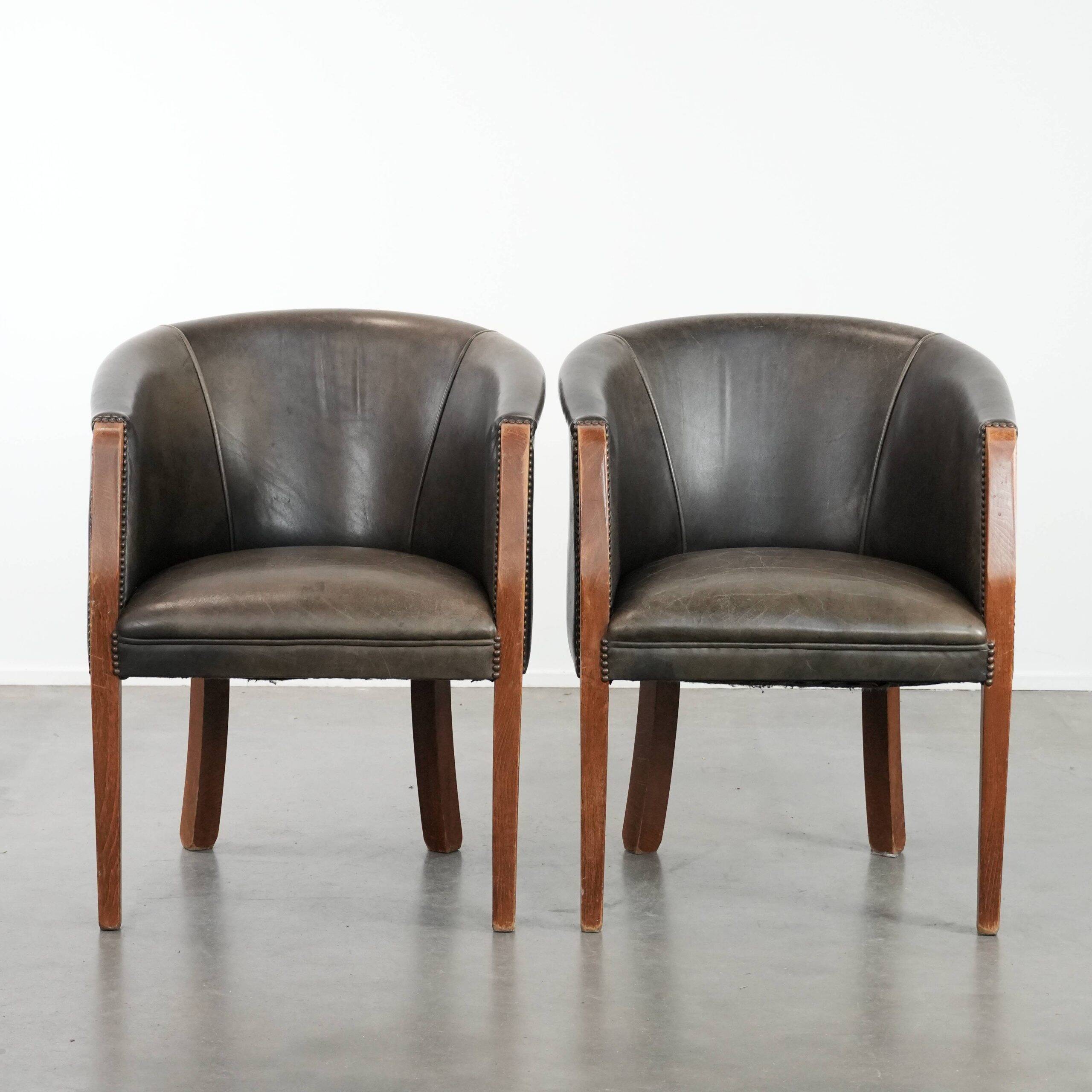 Set of two cowhide and wooden tub chairs with a sturdy colour scheme