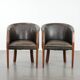 Set of two cowhide and wooden tub chairs with a sturdy colour scheme
