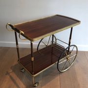 Mahogany and brass rolling table in the style of Maison Jansen.