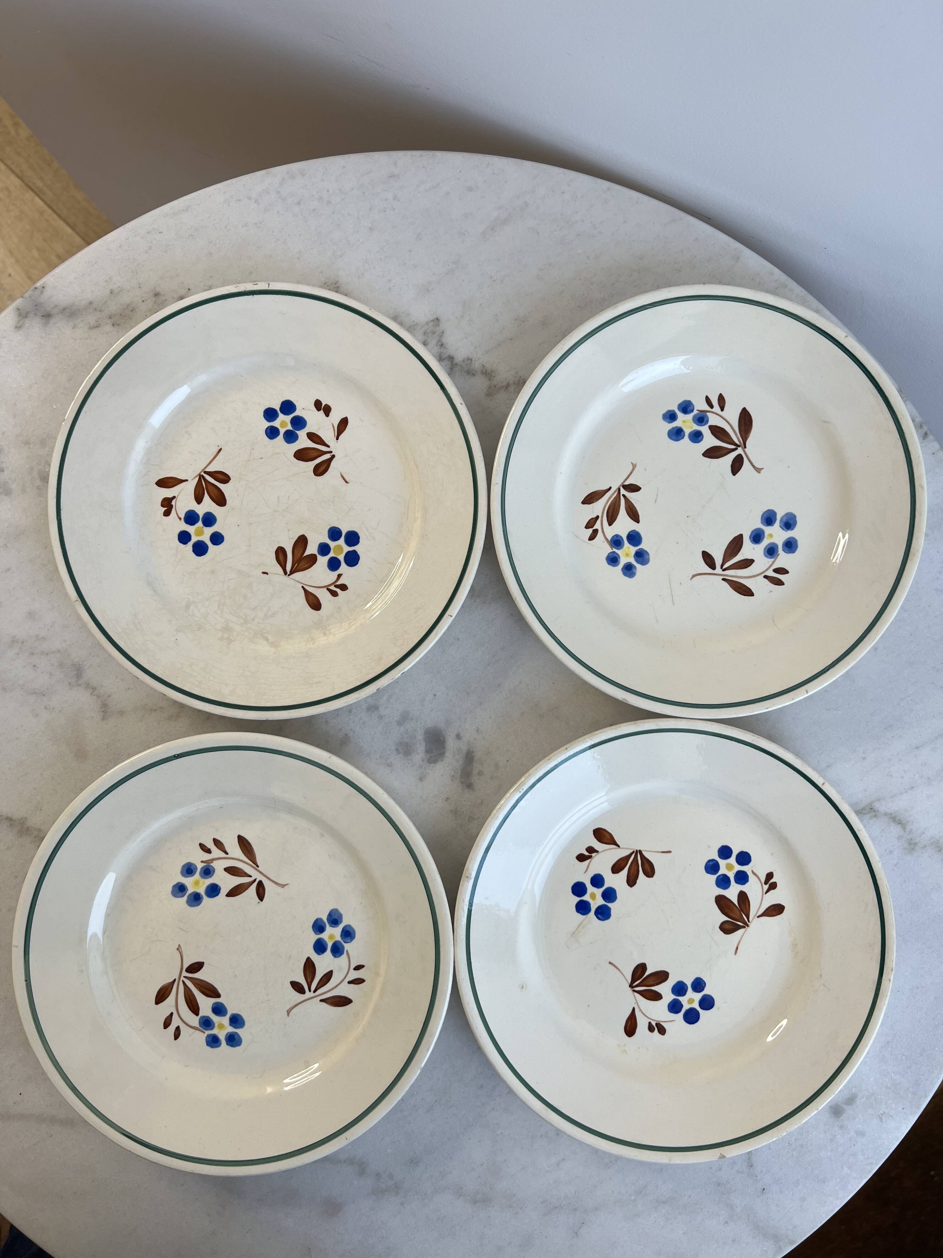 Set of 4 small flat plates with floral designs.