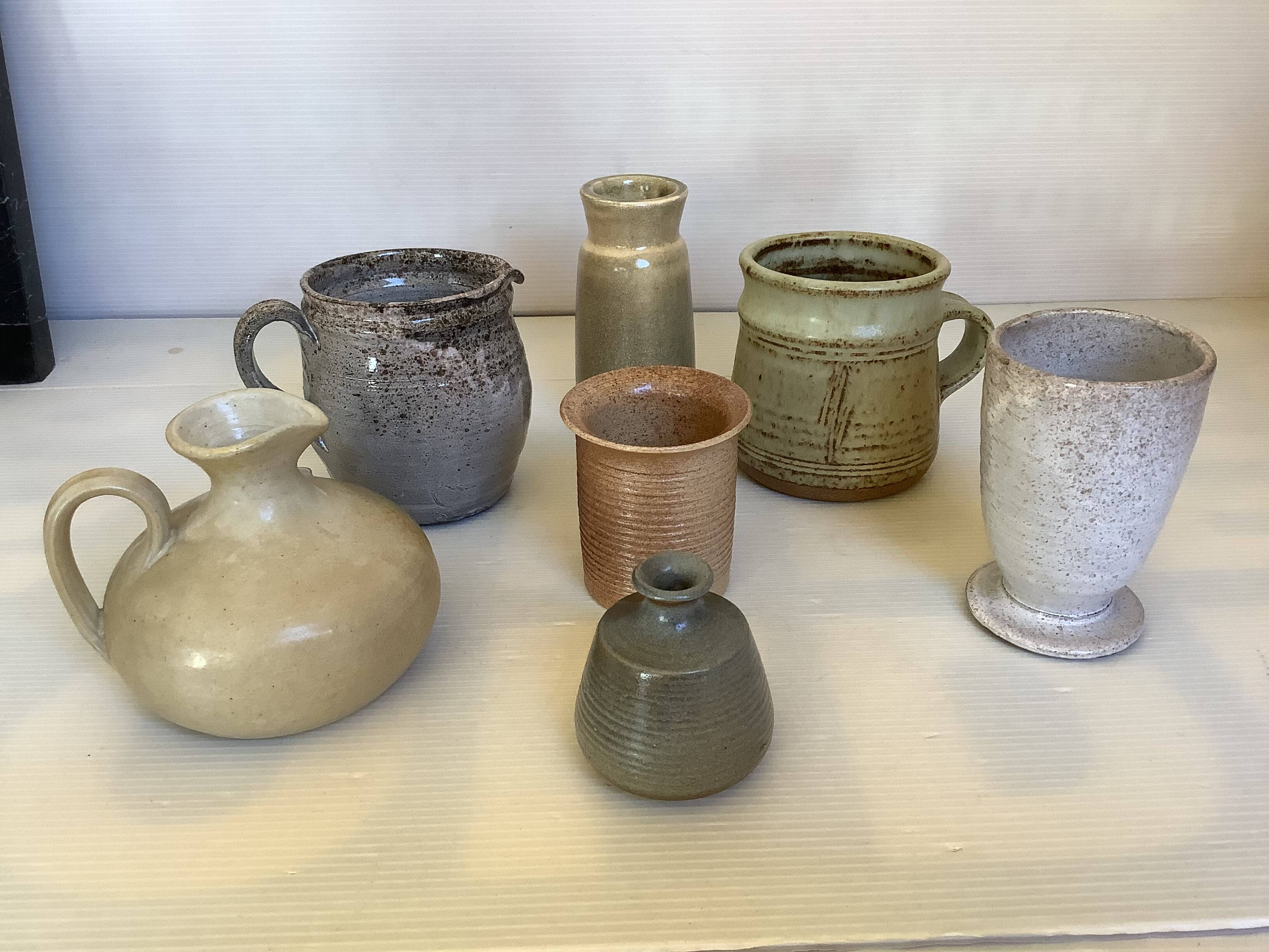 Seven beige and gray ceramic vases