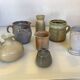 Seven beige and gray ceramic vases
