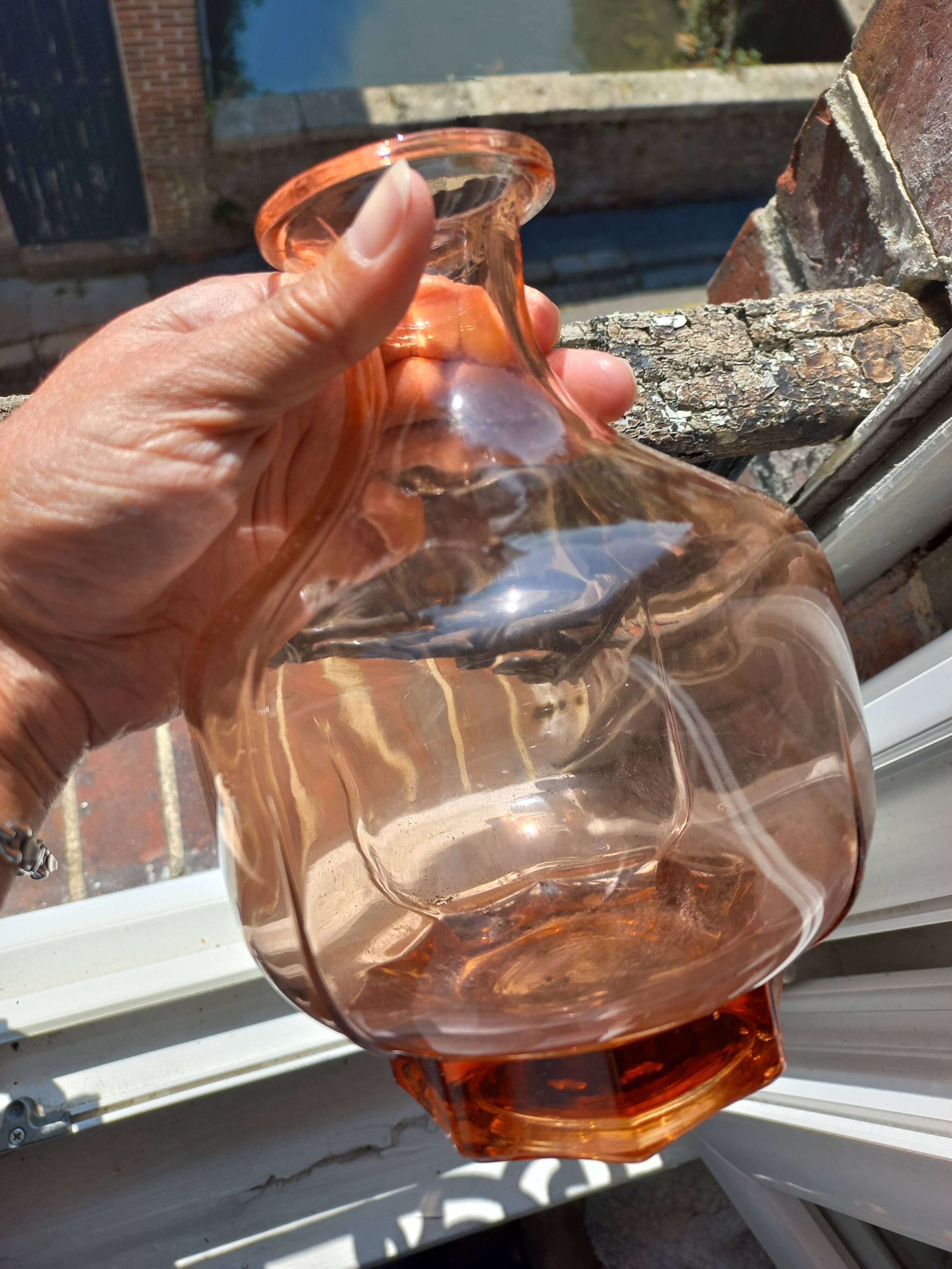 Vintage glass carafe in pink-orange, retro-chic style.