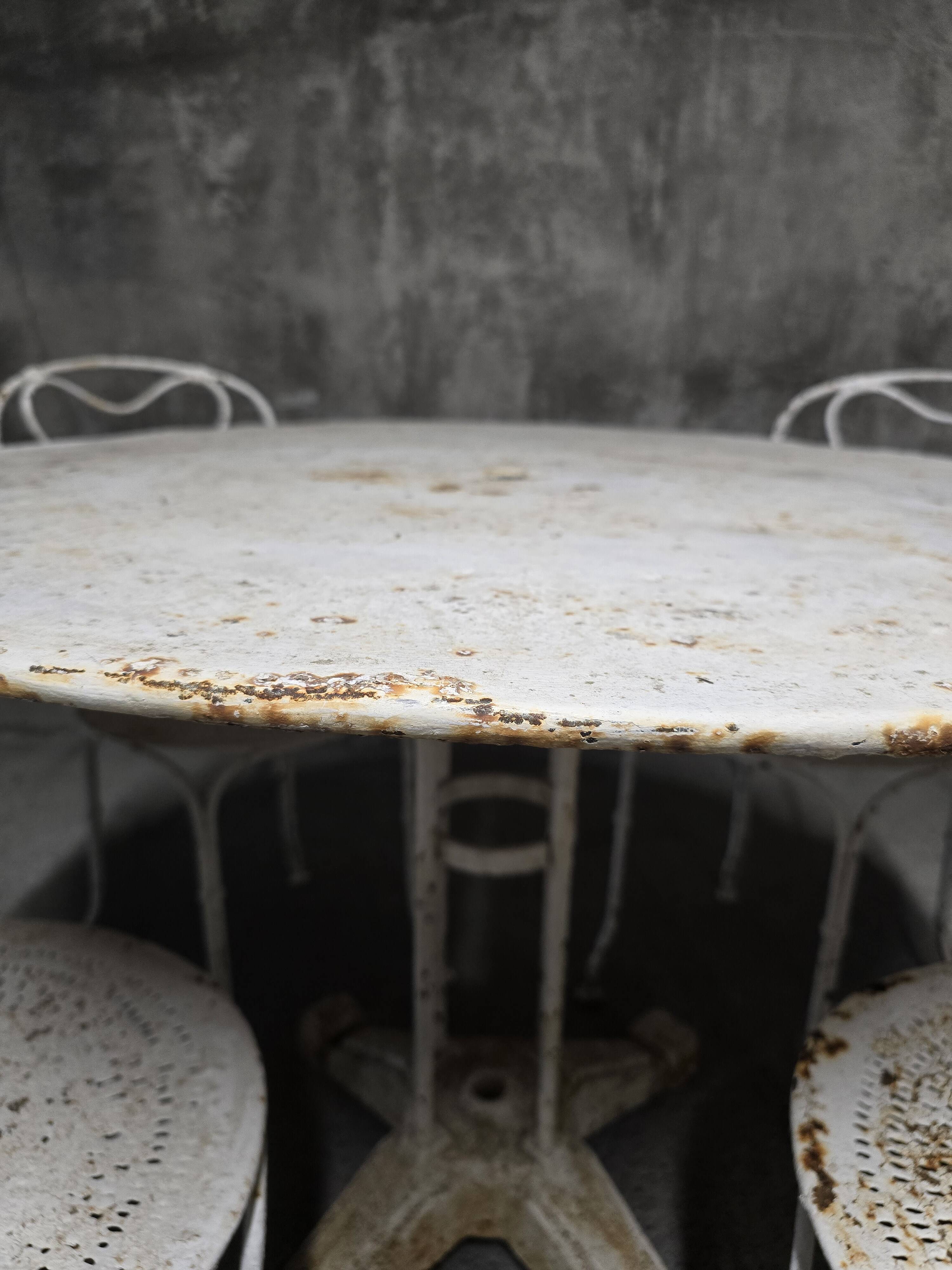 Antique painted wrought iron garden furniture, round table and four chairs.