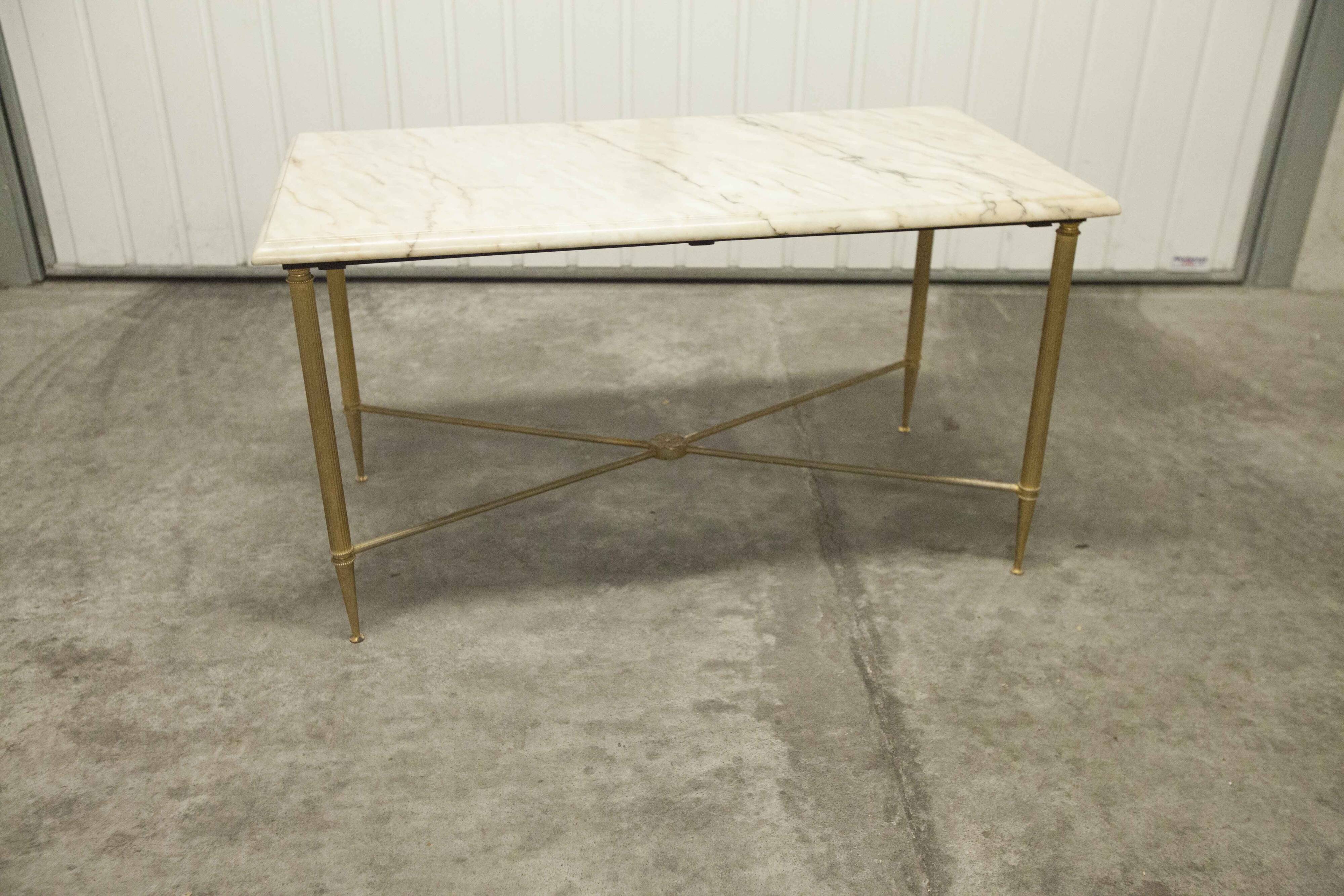 Marble coffee table with brass legs, height 46 cm.