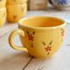 Large vintage ceramic mug in yellow with hand-painted flowers.