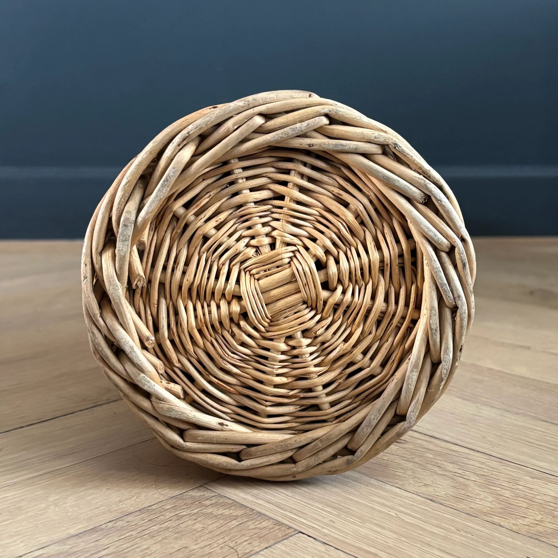 Amber glass bottle in its wicker handle basket.
