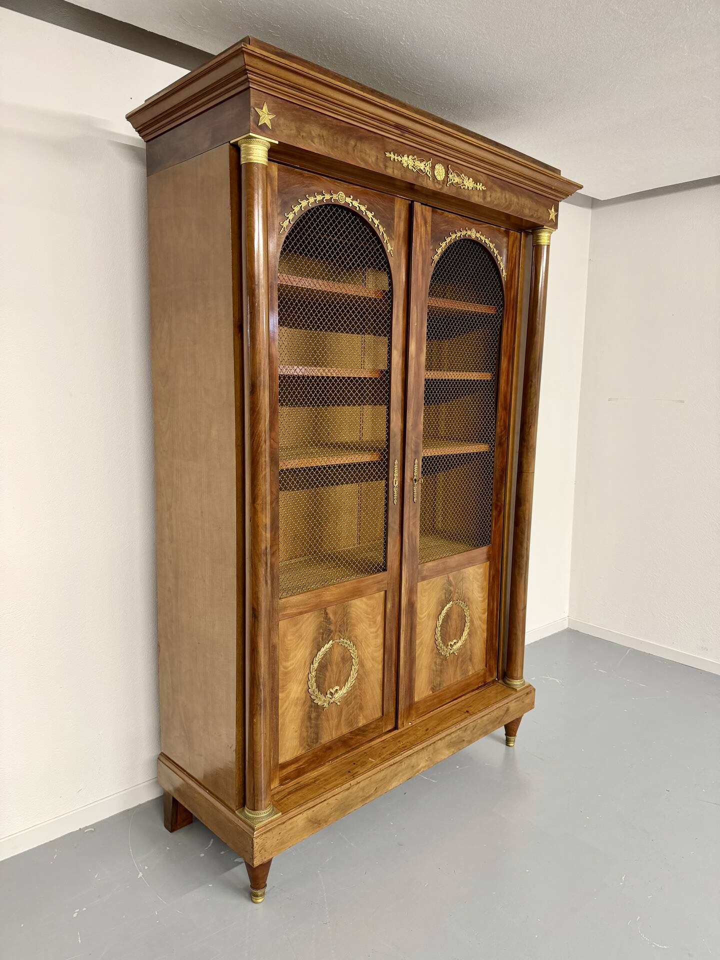 Large Empire-style library in wood with gilded bronze ornaments.