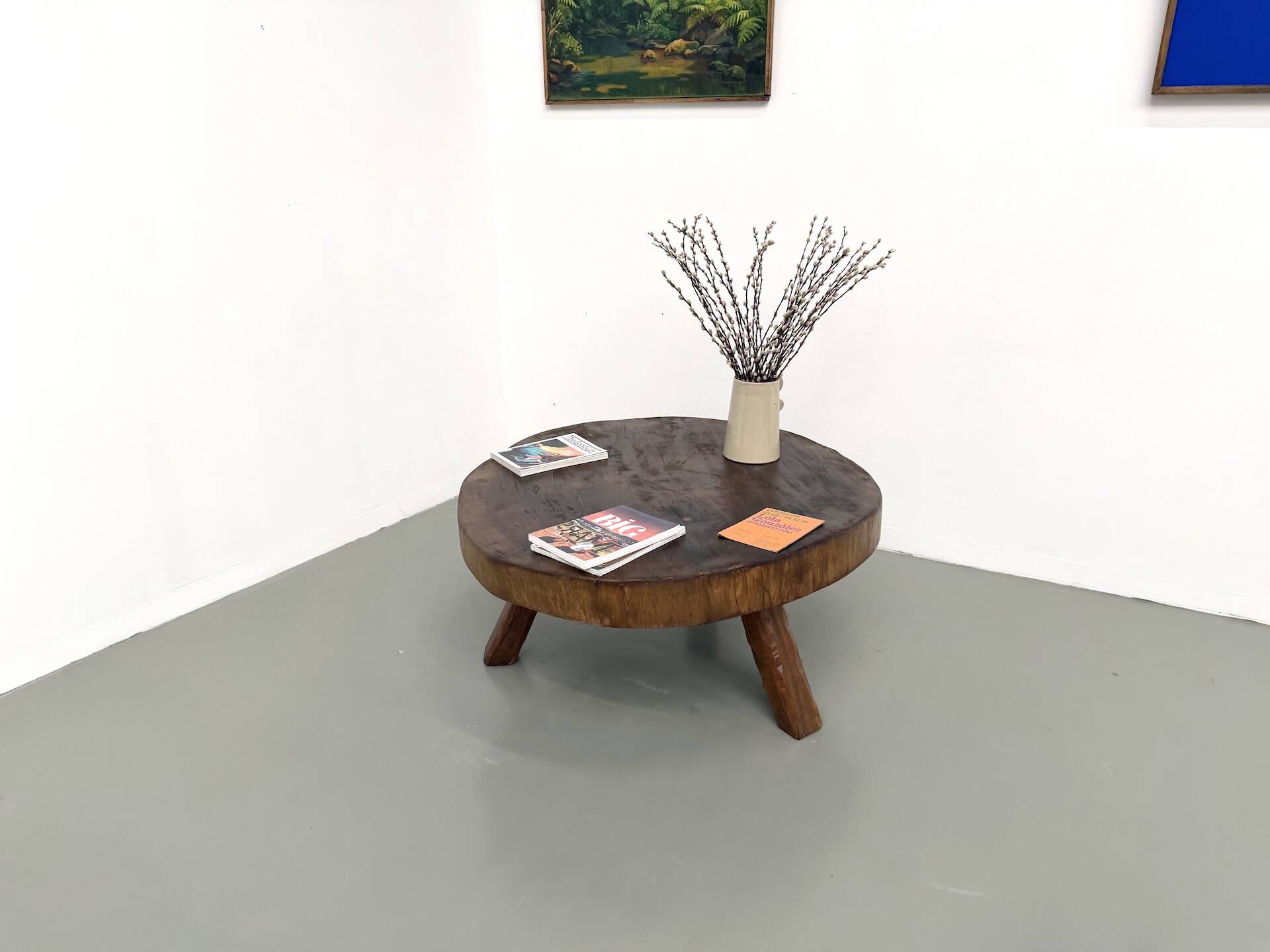 Brutalist coffee table in solid teak, monolithic slab, tripod base.