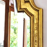 Florentine arched mirror in gilded wood with gold leaf.