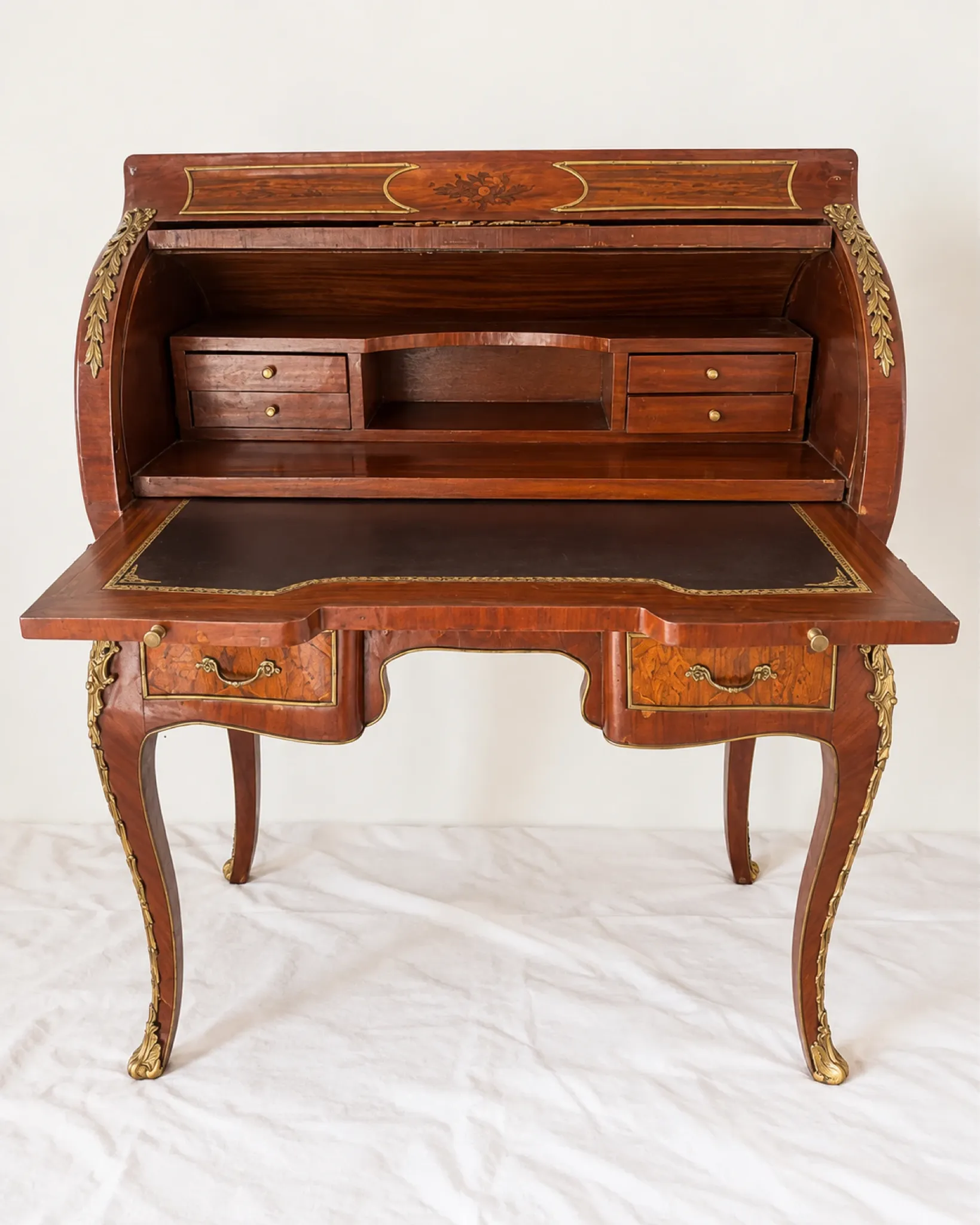 Louis XV cylinder desk with floral marquetry and gilded ornaments.