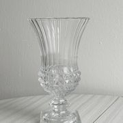 Antique thick glass vase on a pedestal.