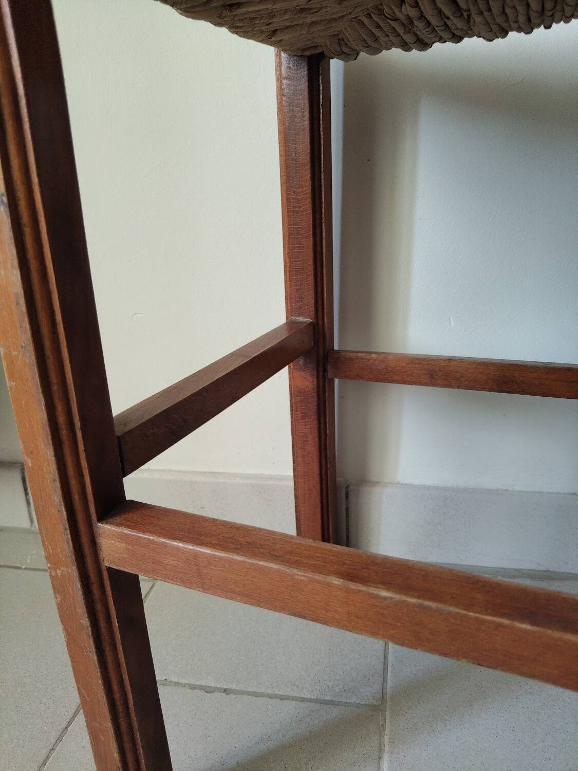 Antique campaign stool in solid wood with a straw seat.