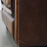 A well-maintained cowhide leather English Chesterfield armchair