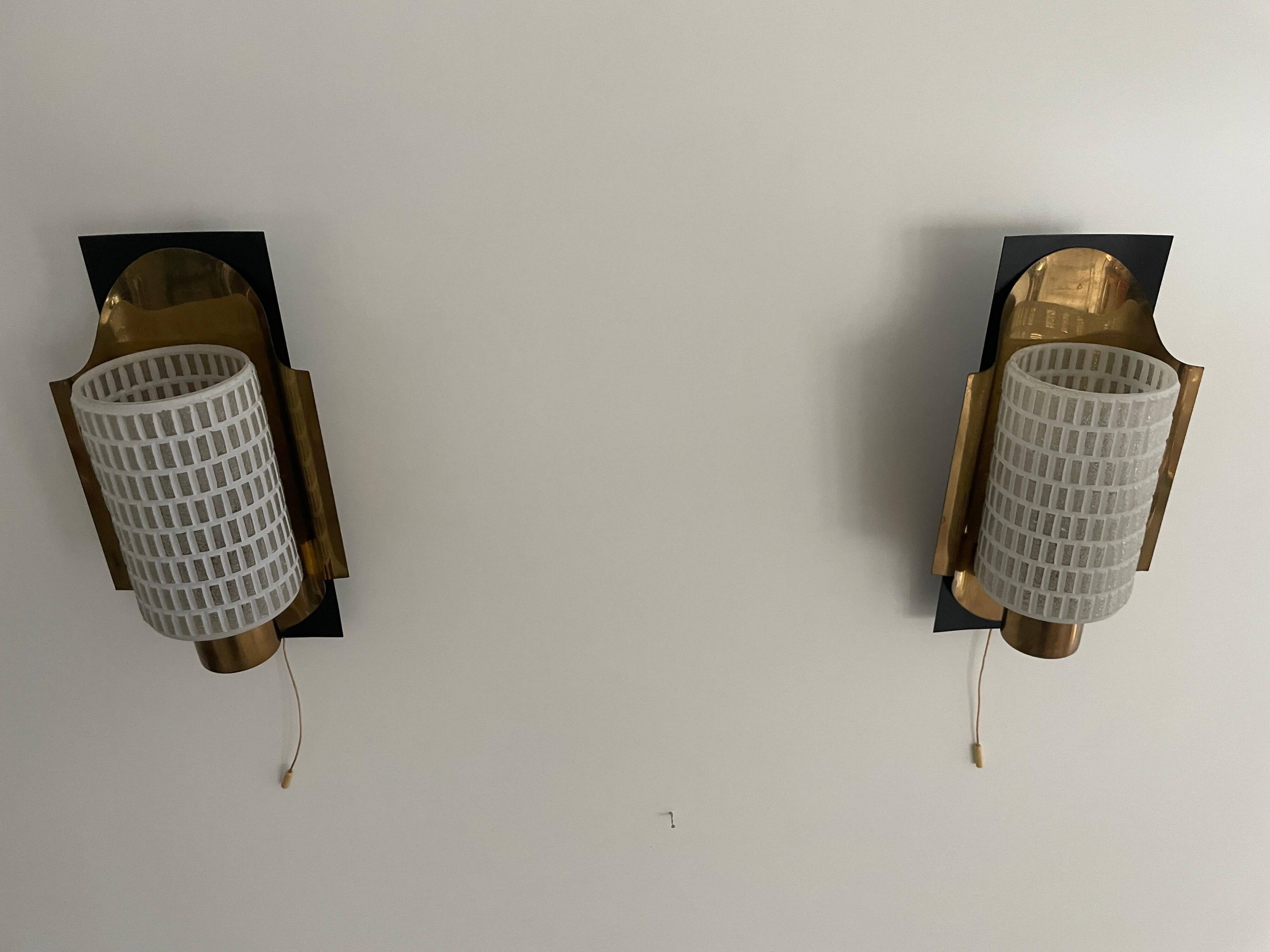 Mid-century pair of wall sconces in textured glass and brass, 1950s, Germany.